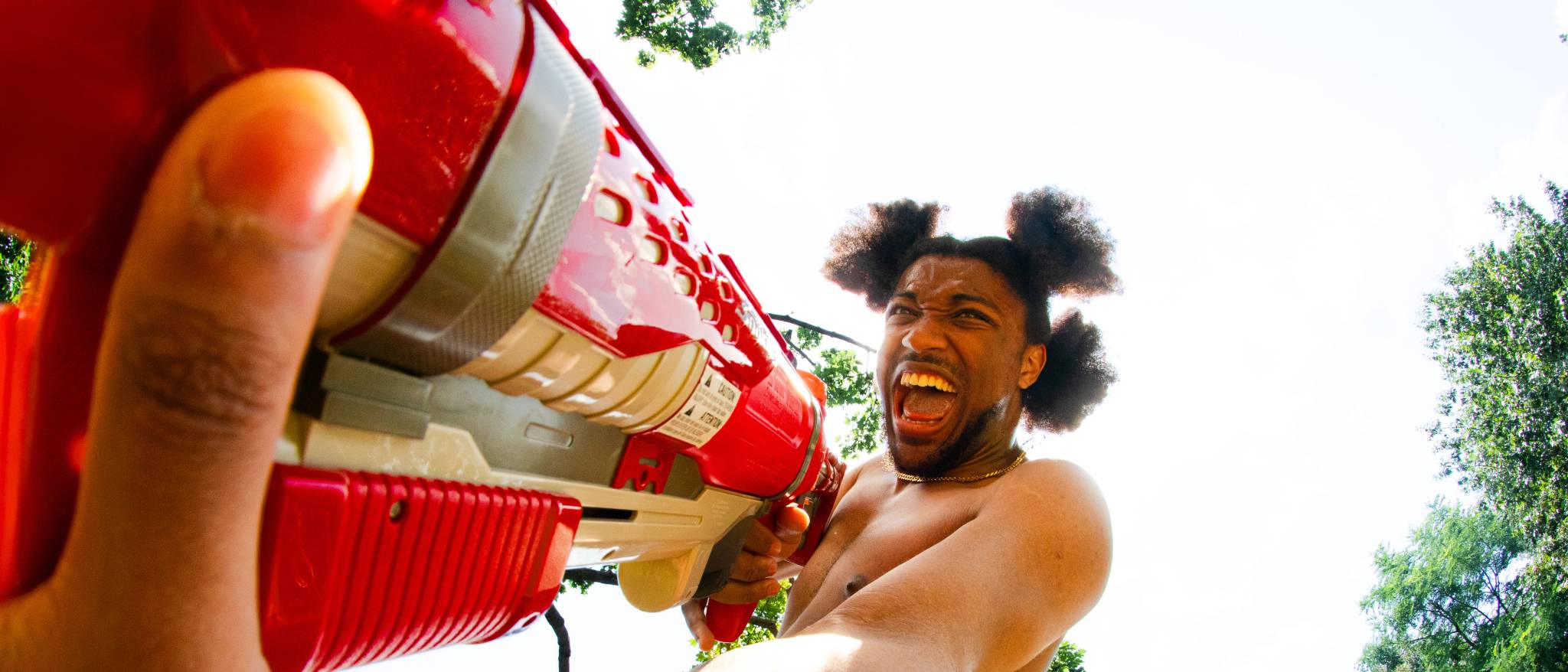 A fisheye wide-angle shot of KEND! brandishing a watergun.